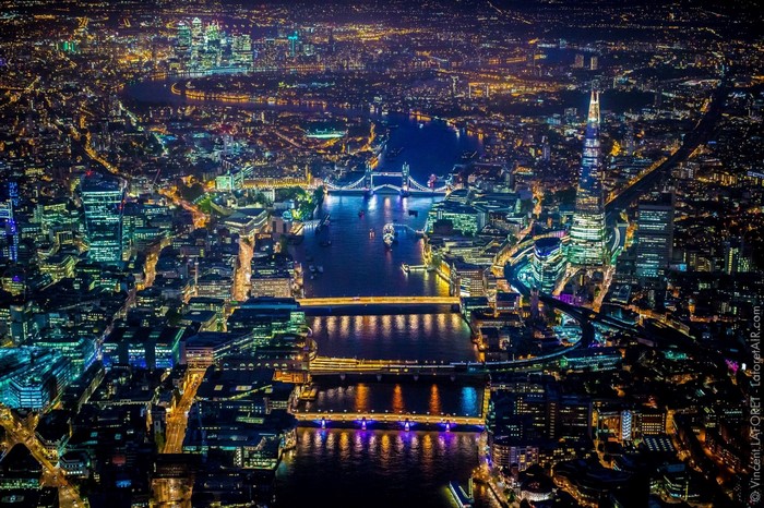 Aerial view of London cityscape at night with River Thames and Tower Bridge