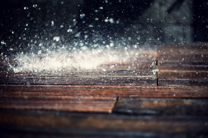 Water droplets on a wooden surface with bokeh