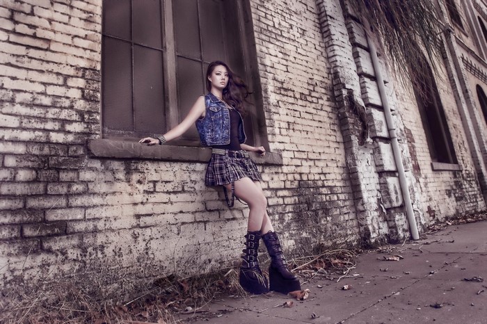 Model in Plaid Skirt and Platform Boots Against Brick Wall