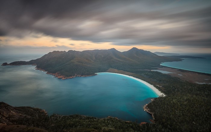 Wine Glass Bay, Tasmania at sunrise with mountains and ocean