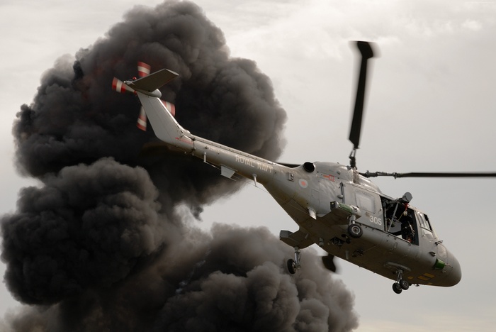 Royal Navy Westland Lynx helicopter flying near black smoke