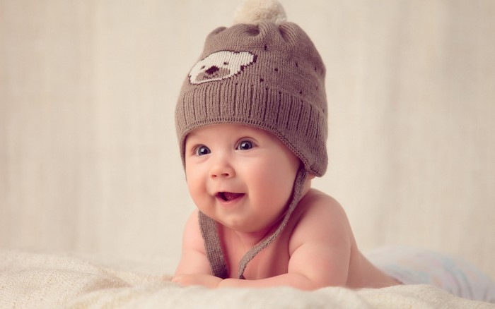 Baby wearing a brown knit hat with a bear design