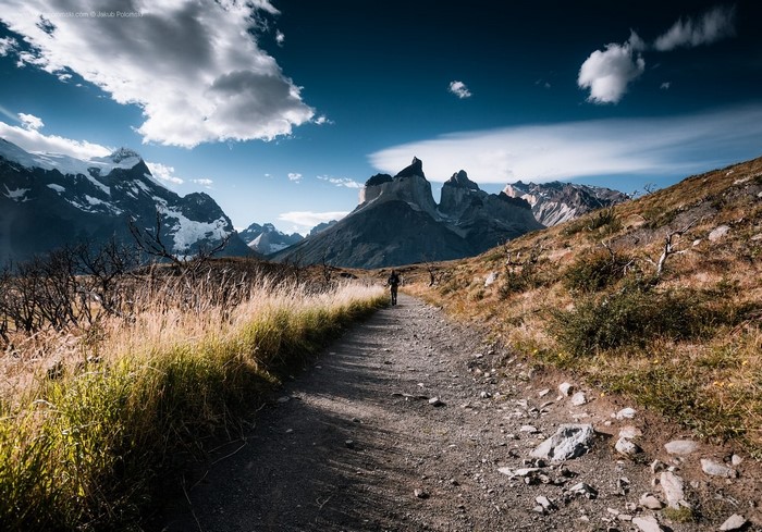 Hiker on a trail with mountains in the background