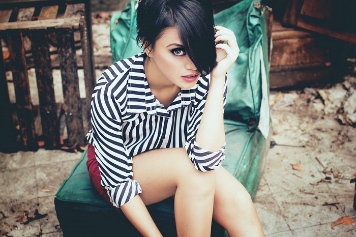 Woman in striped shirt and red shorts sitting