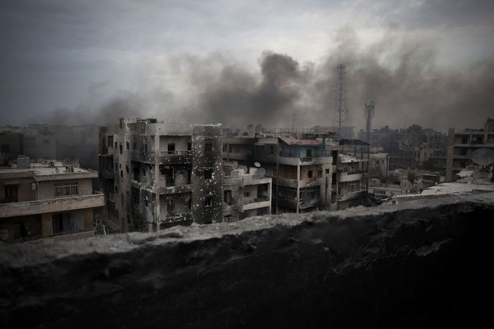 Ruined cityscape with smoke in Aleppo, Syria