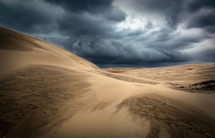 Sand dunes under stormy clouds