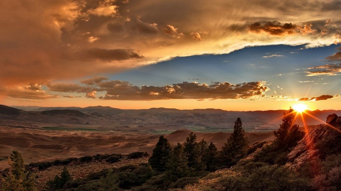 Sunset over a mountainous valley with trees