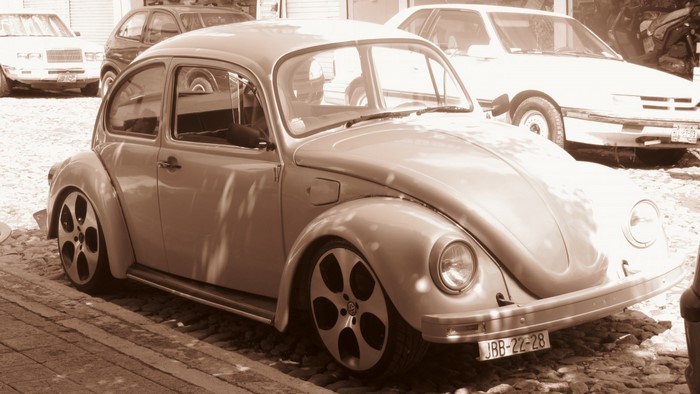 Sepia toned Volkswagen Beetle with custom wheels