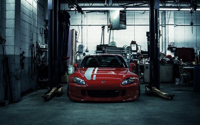 Red Honda S2000 in a garage with car lift