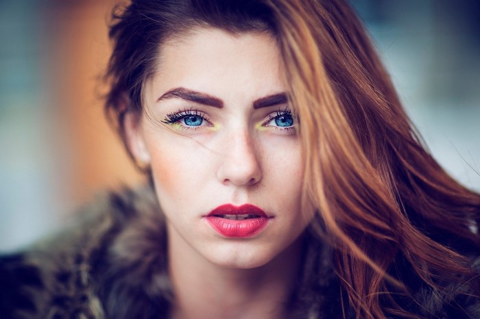 Woman with blue eyes and red lips, close-up portrait