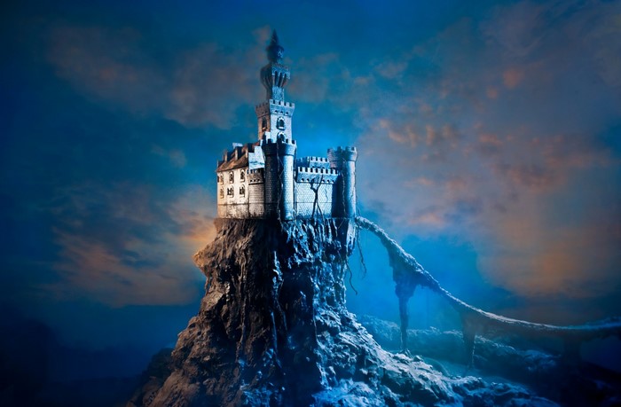 Fantasy castle on a rocky mountain peak under a cloudy sky