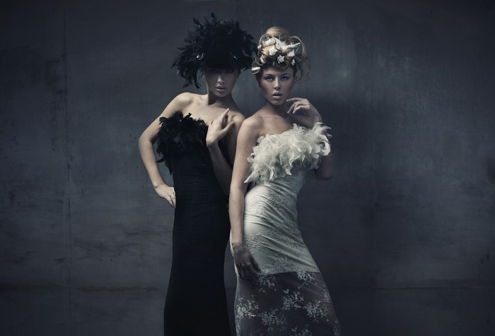 Two women in elegant dresses and elaborate headwear