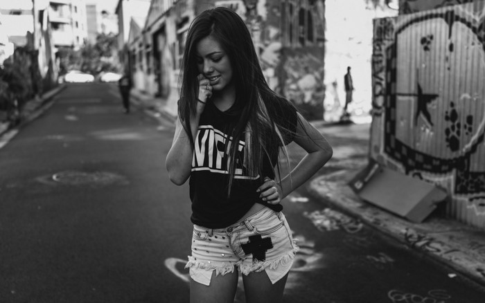 Woman in jean shorts and t-shirt in alley