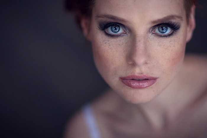 Close up portrait of a redhead woman with blue eyes and freckles