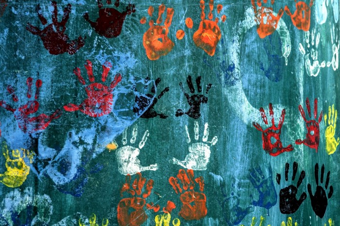 Colorful handprints on a textured teal wall