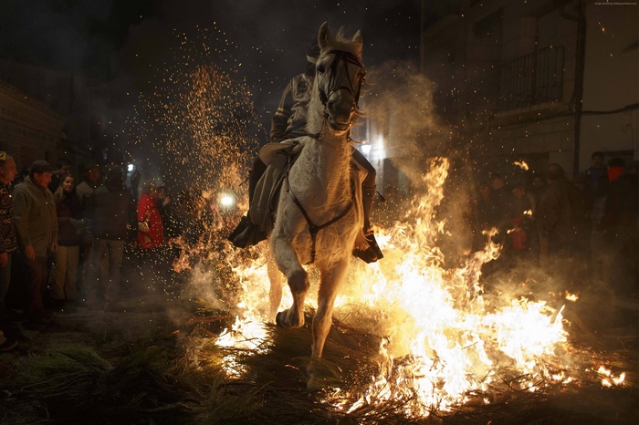 Man riding a horse through fire during a festival