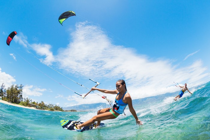 Women and men kitesurfing on a sunny day