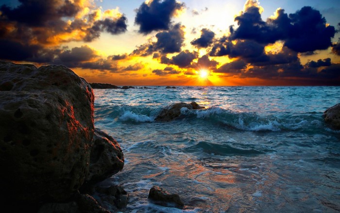 Sunset Over Rocky Shore with Vibrant Sky