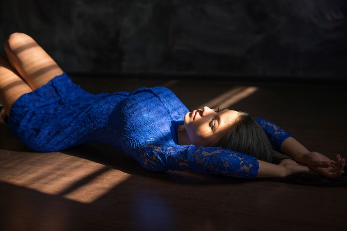 Woman in Blue Dress Lying in Sunlight