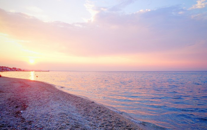 Sunset over the sea with a beach in the foreground
