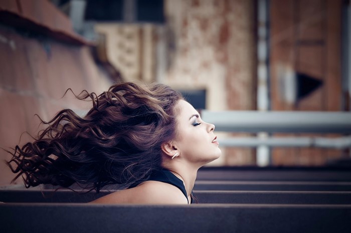 Woman with windblown curly hair in profile