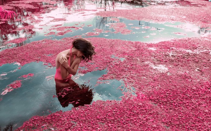 Woman in pink swimsuit in pink water with reflections