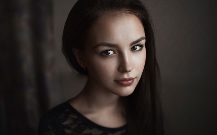 Woman with long dark hair in a black lace top