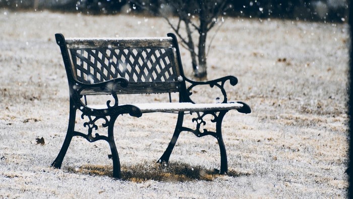 A snow-covered park bench in winter