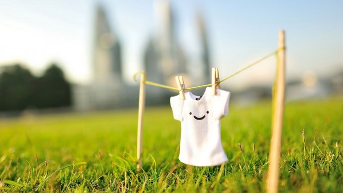 Miniature T-shirt with smiley face drying on a clothesline
