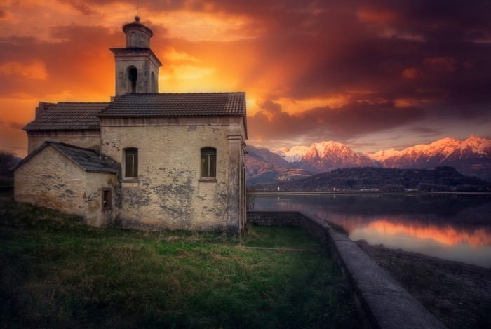 Church by the lake at sunset with mountains
