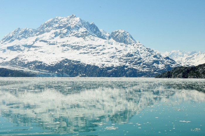 Snow-capped mountains reflected in icy water