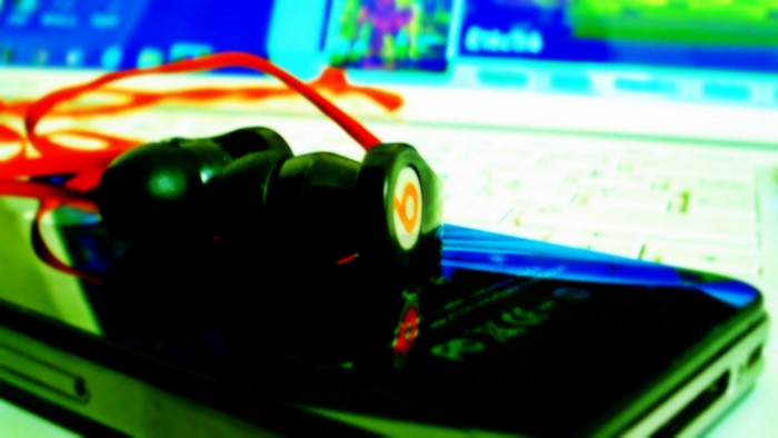 Black Beats headphones with red cord on phone