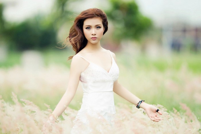 Elegant Woman in White Dress Among Grass