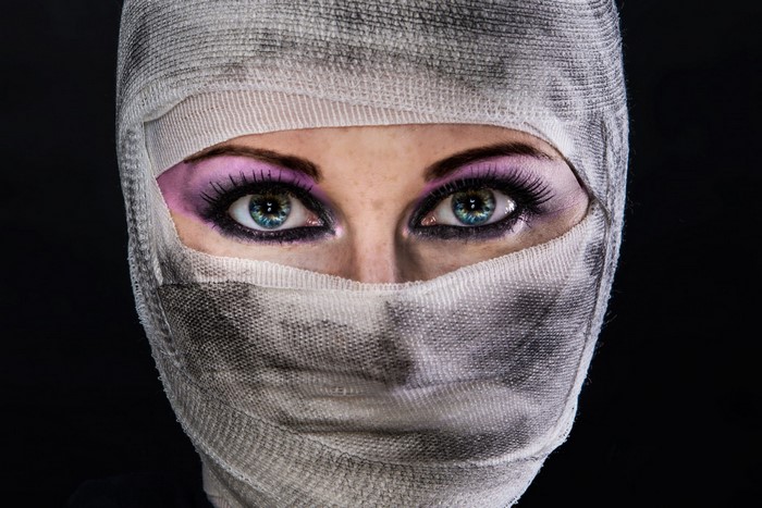 Woman with eyes and nose covered in bandages