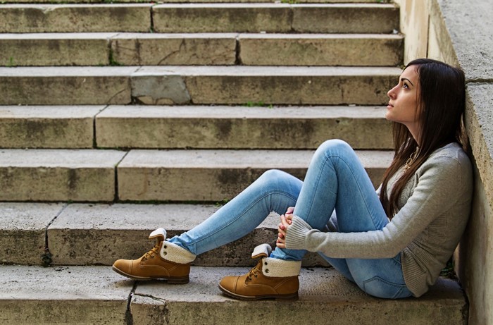 Woman sitting on stone stairs