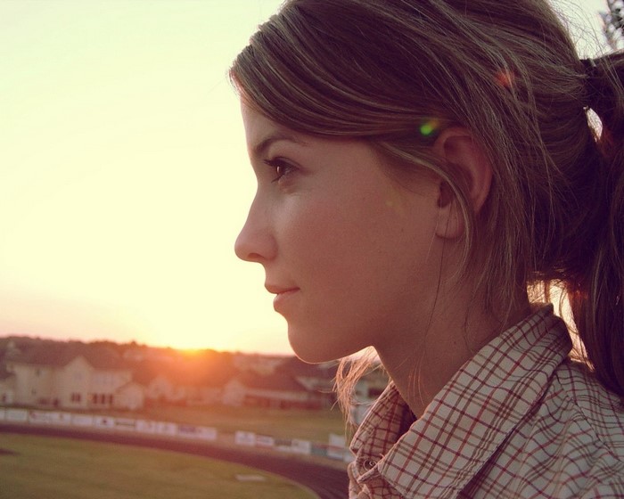 Woman in plaid shirt looking at sunset