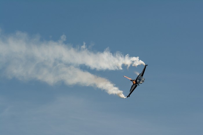 F-16 Fighting Falcon performing aerobatics with smoke trails