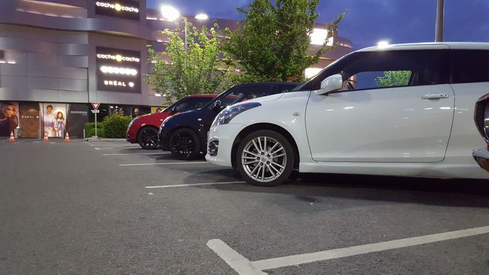 Suzuki Swift cars parked in a lot at dusk