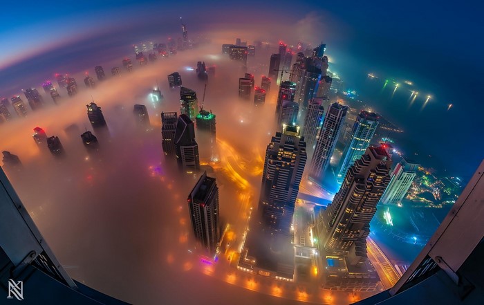 Dubai cityscape shrouded in mist at night from above