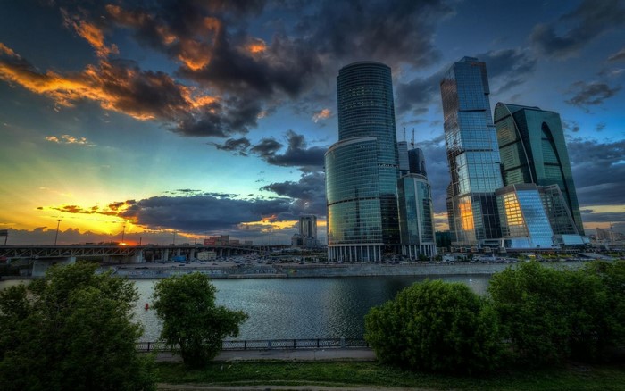 Cityscape with skyscrapers and river at sunset