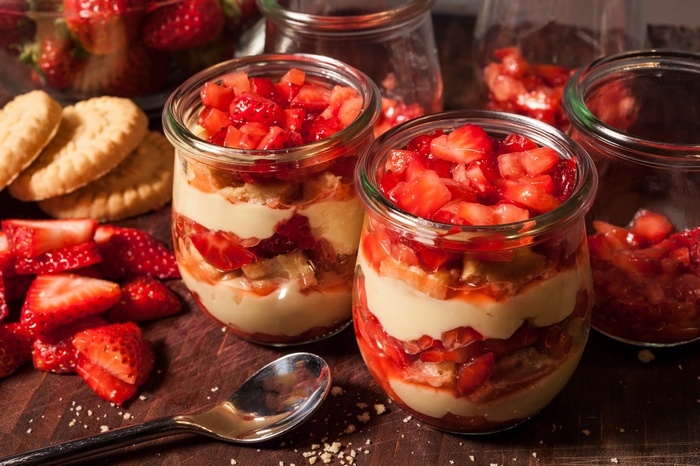 Strawberry trifle in jars with cookies and spoon