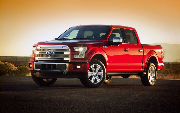 Red Ford F-150 pickup truck on a road