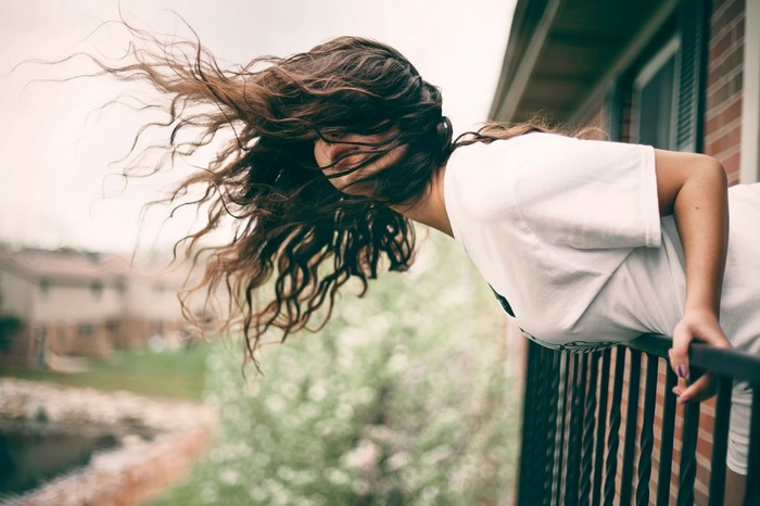Woman with long hair on a balcony