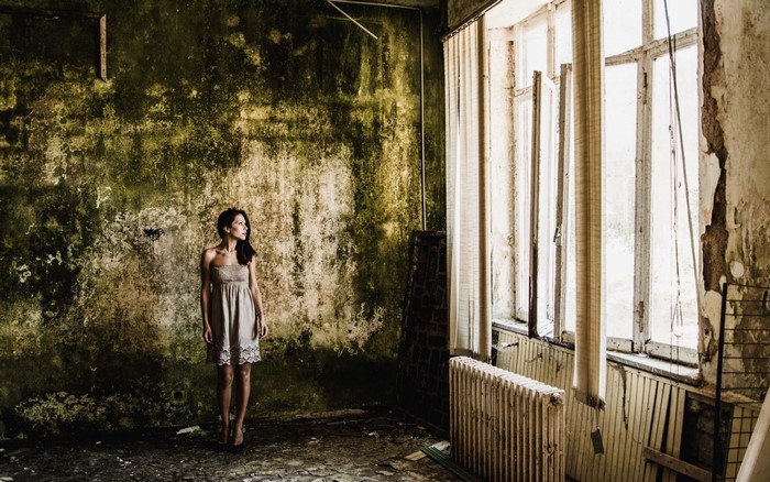 Woman in a dress in a derelict room
