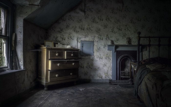 Abandoned bedroom with dresser and fireplace