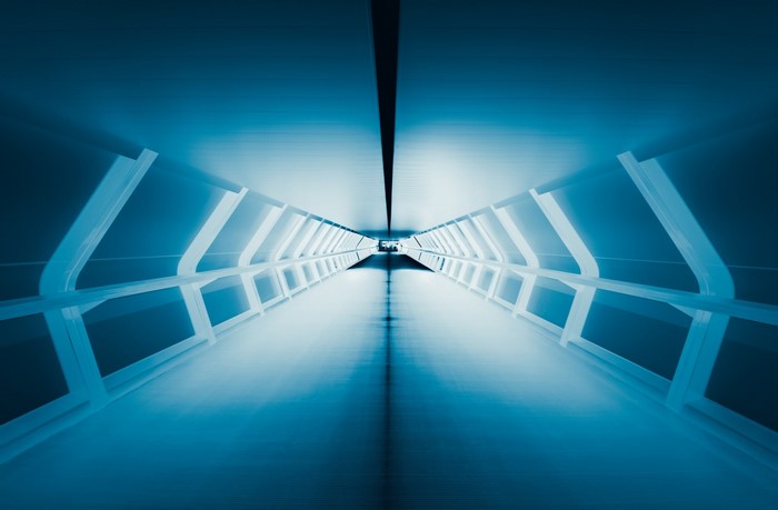 Blue futuristic tunnel with symmetrical lighting