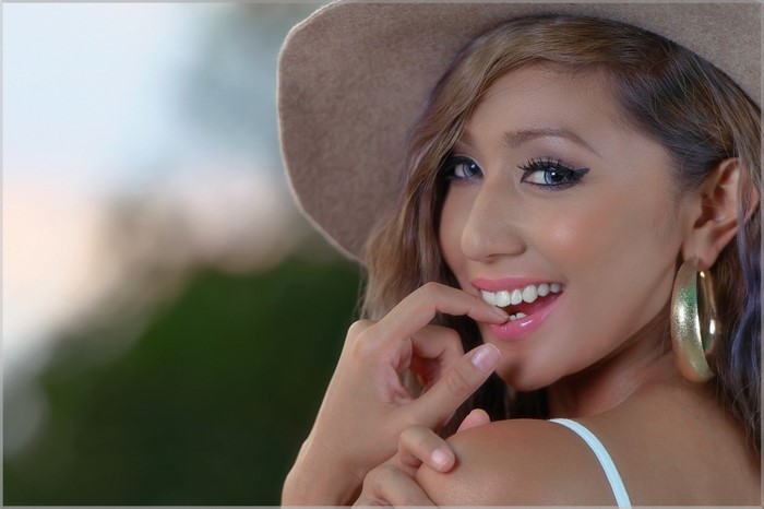 Woman wearing a hat and hoop earrings, close-up portrait