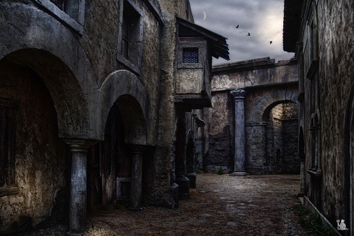 Ancient ruins with arches and columns under a cloudy sky