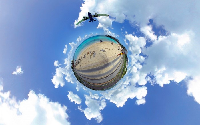 Airplane flying over a beach in a panoramic sphere
