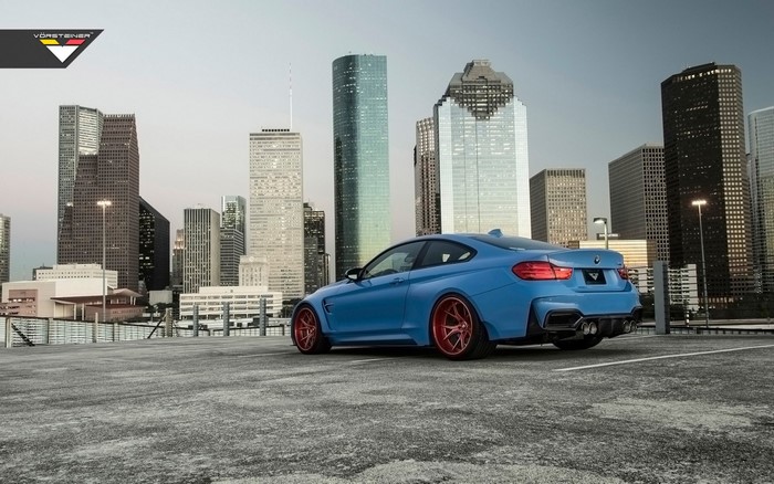 Blue BMW M4 GTRS4 by Vorsteiner with red wheels in city